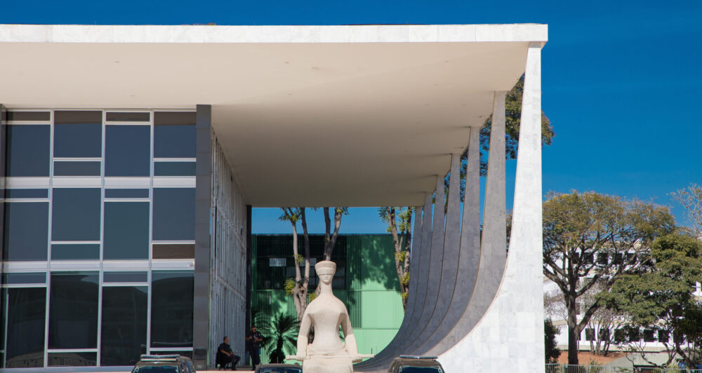Edifício-sede do STF com estátua da Justiça em primeiro plano