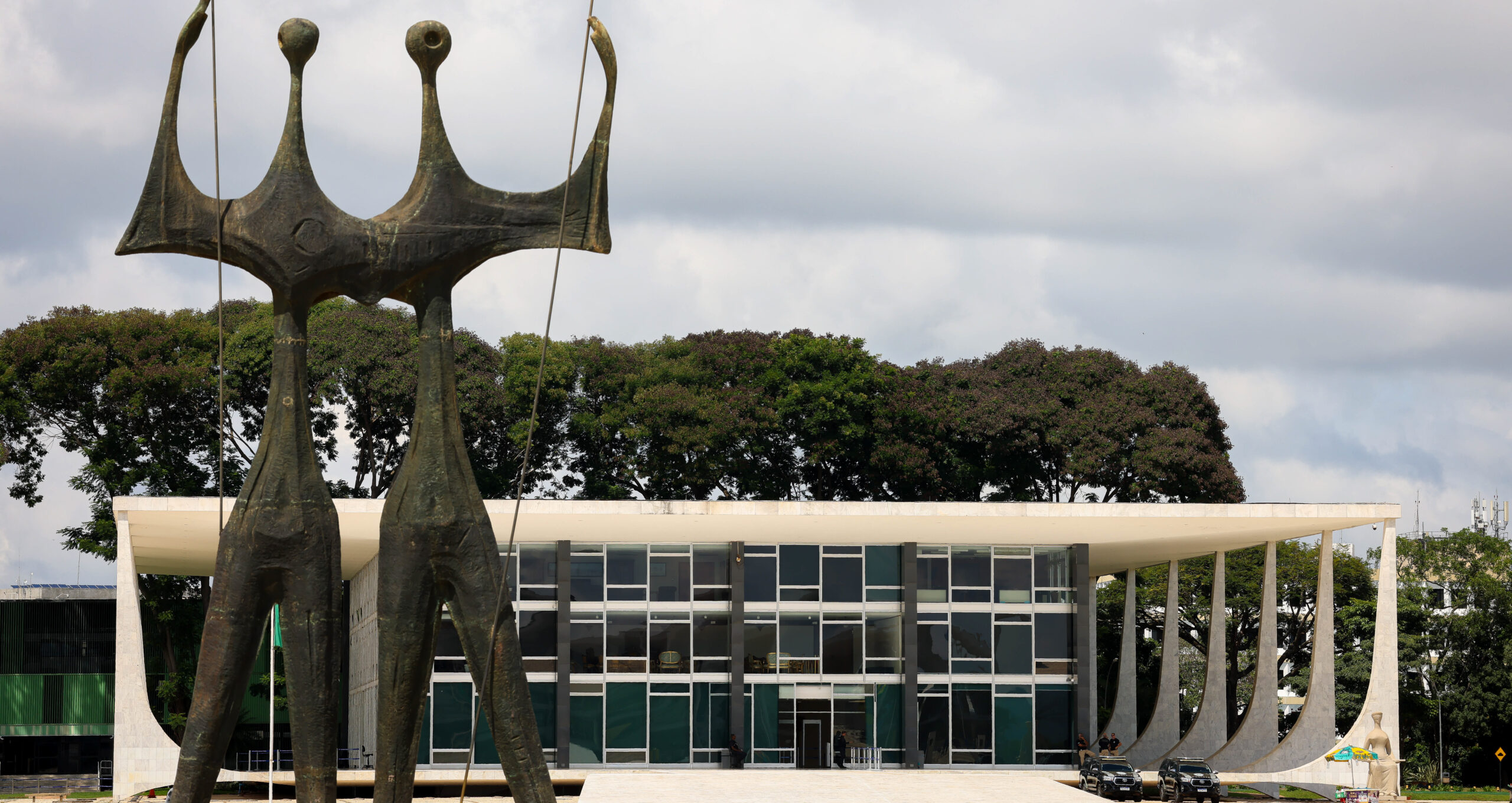 Foto colorida na horizontal mostra escultura Dois Candangos, na Praça dos Três Poderes, com o STF ao fundo