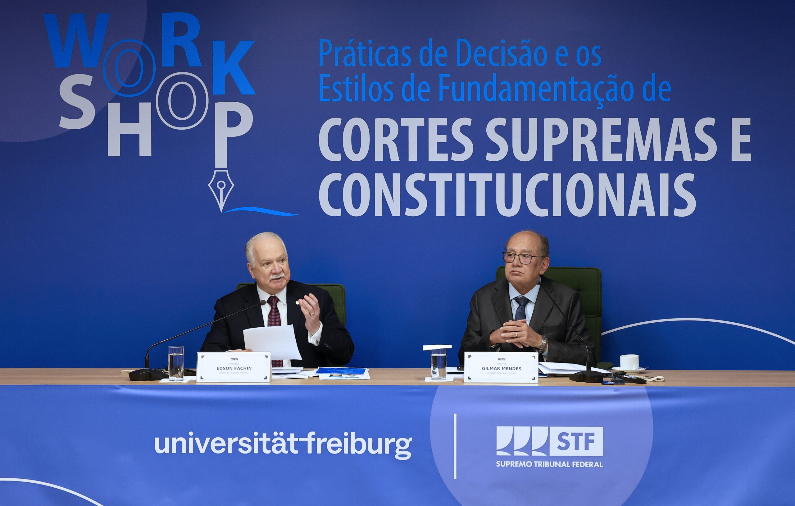 Fotografia dos ministros Edson Fachin e Gilmar Mendes sentados à mesa do evento.