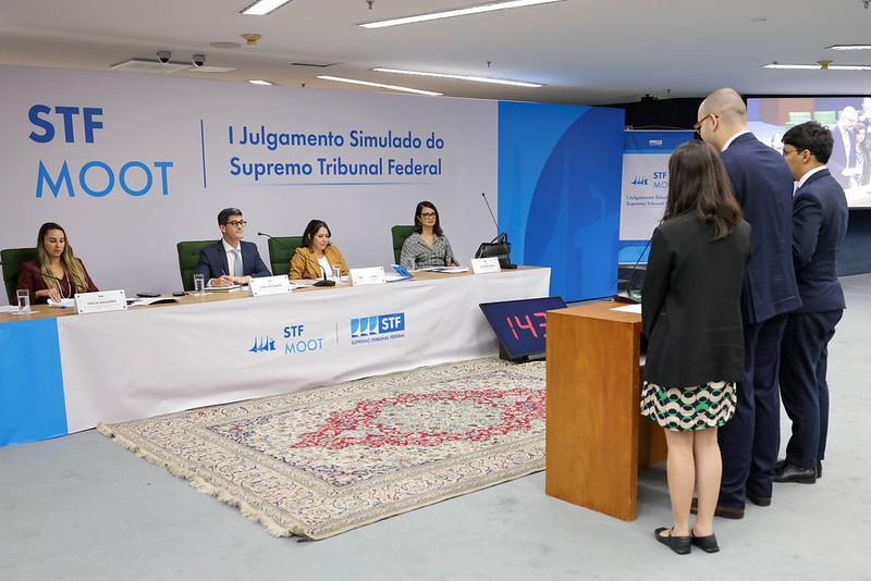 Estudantes fazendo sustentação oral no julgamento simulado perante a bancada dos avaliadores