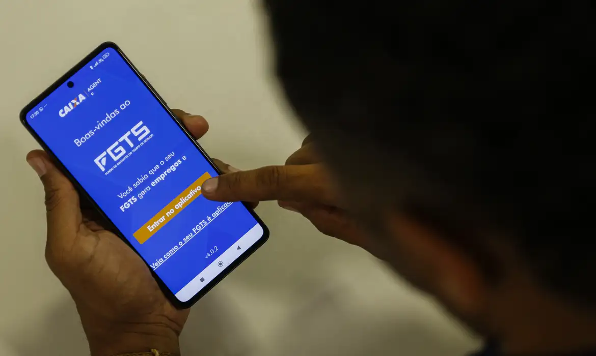 Pessoa usando o aplicativo do FGTS em telefone celular