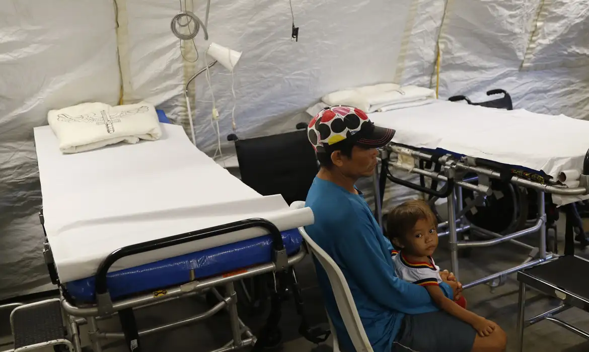 Ambulatório de saúde com homem e criança indígena
