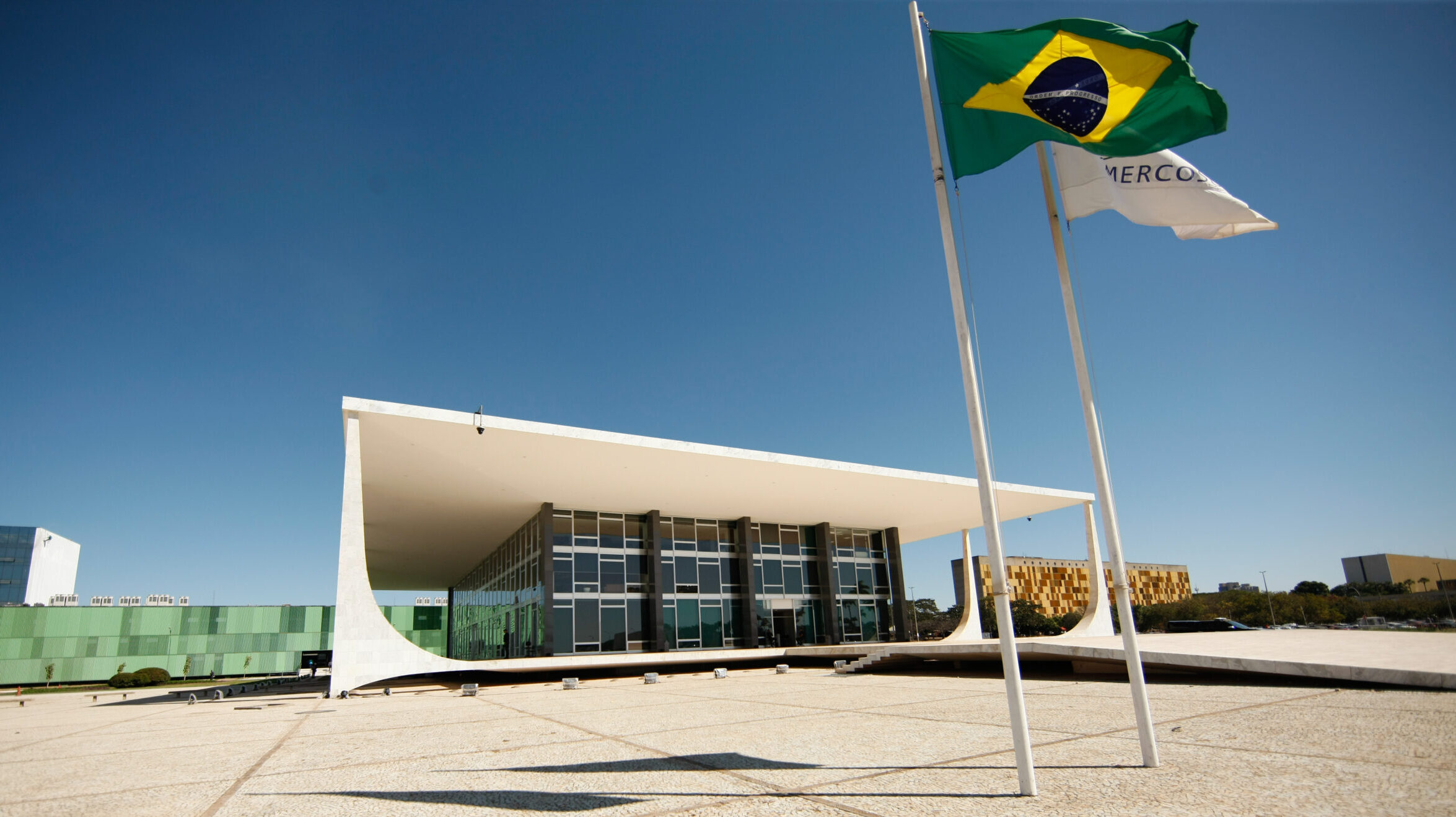 Fachada do prédio do STF com bandeiras do Brasil e do Mercosul em primeiro plano