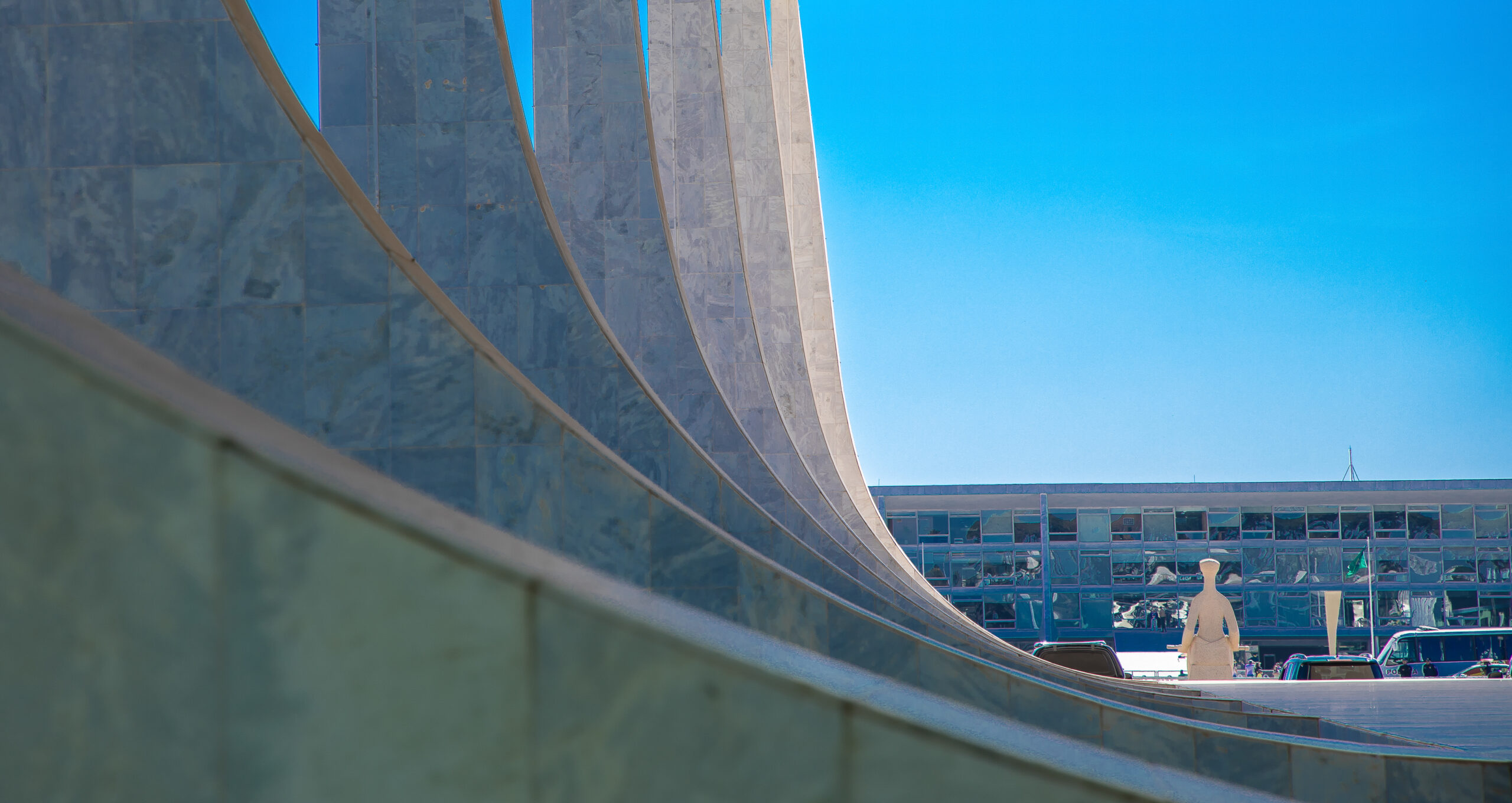 Detalhe das colunas do edifício-sede do STF com Estátua da Justiça ao fundo