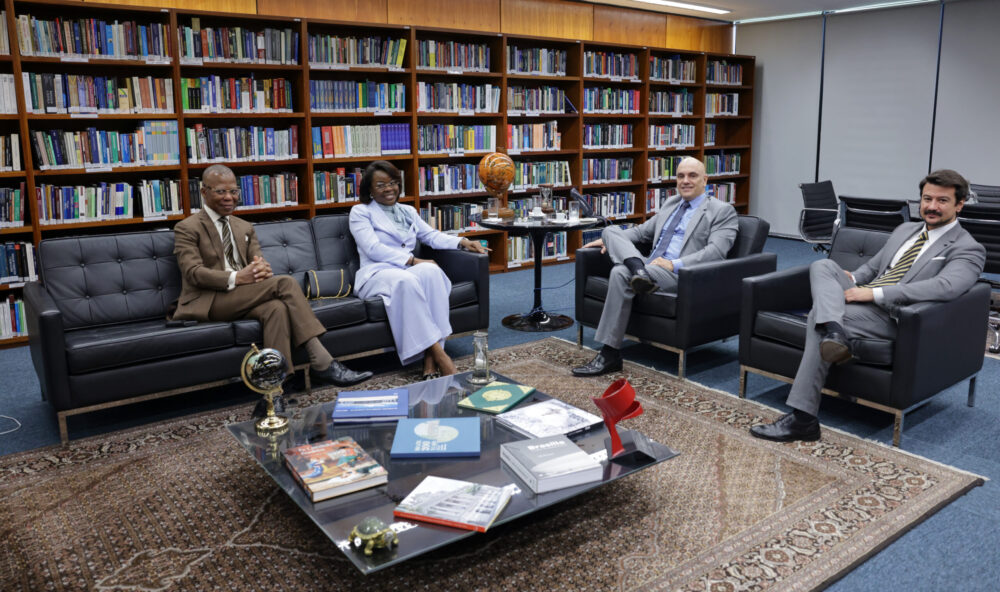 Ministro Alexandre de Moraes e membros da comitiva sentados em sofás no momento da visita