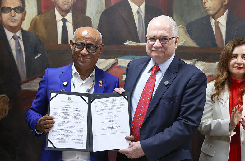 Ministro Edson Fachin e reitor da UFPA posando para foto com o acordo de parceira assinado.
