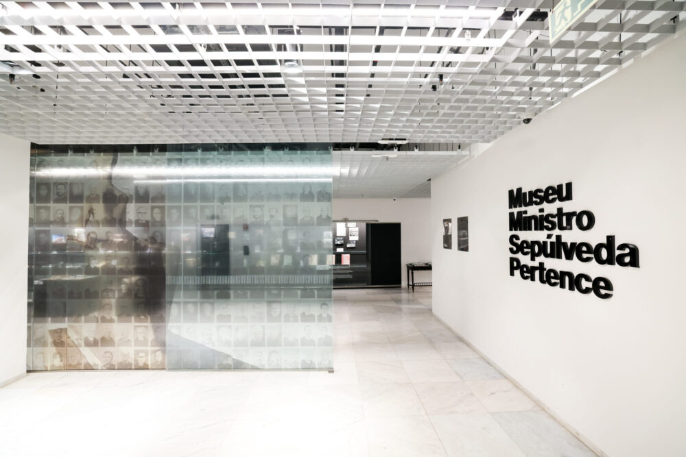 Entrada do Museu do STF Ministro Sepúlveda Pertence com parede de vidro com fotos de ministros ao fundo