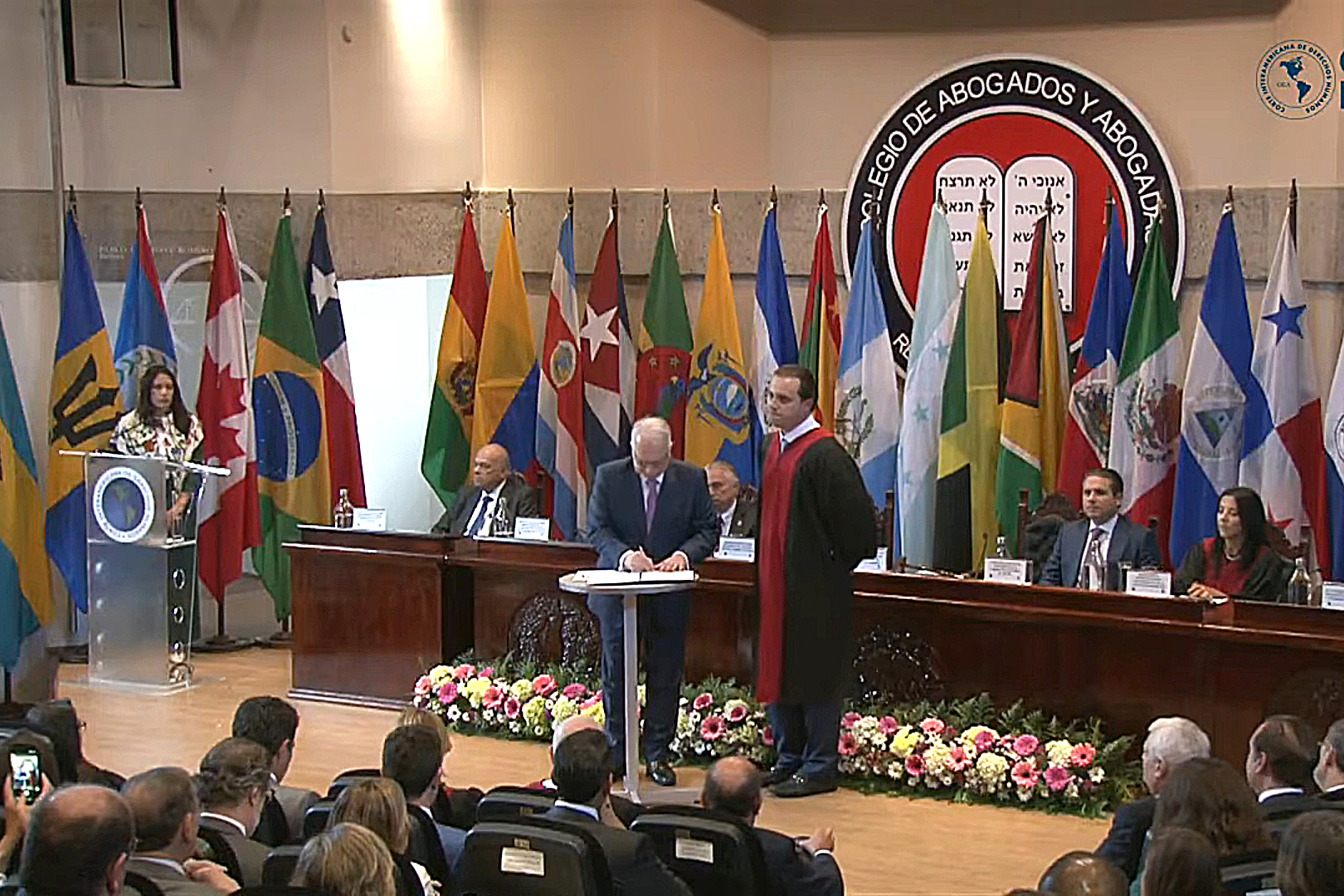 Fotografia do ministro Edson Fachin assinando termo de compromisso diante de um auditório.