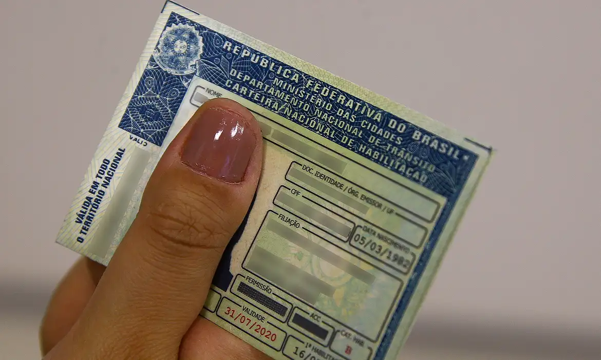 Detalhe de mão segurando uma CNH