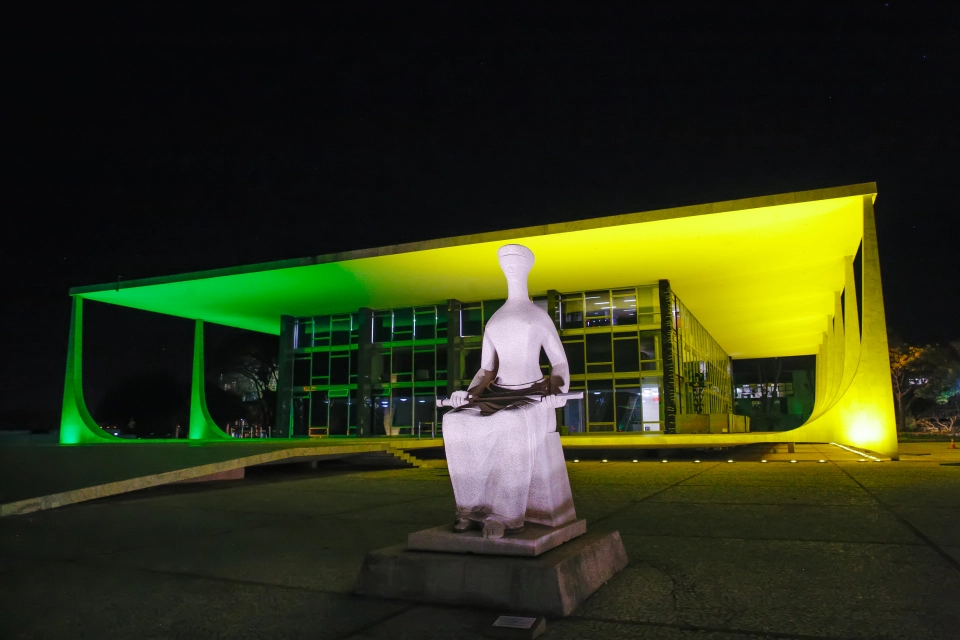 Fachada do edifício-sede do STF iluminada em verde e amarelo