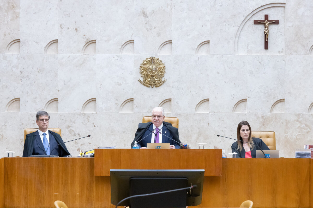 Fotografia colorida da bancada central do Plenário do STF. O ministro Fachin está ao centro, ladeado pelo procurador-geral da República, Paulo Gonet, e assessor do Plenário.