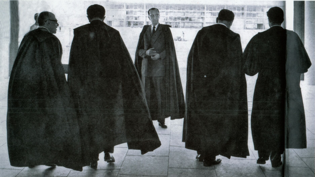 Fotografia em preto e branco de ministros se preparando para sessão de instalação do STF.