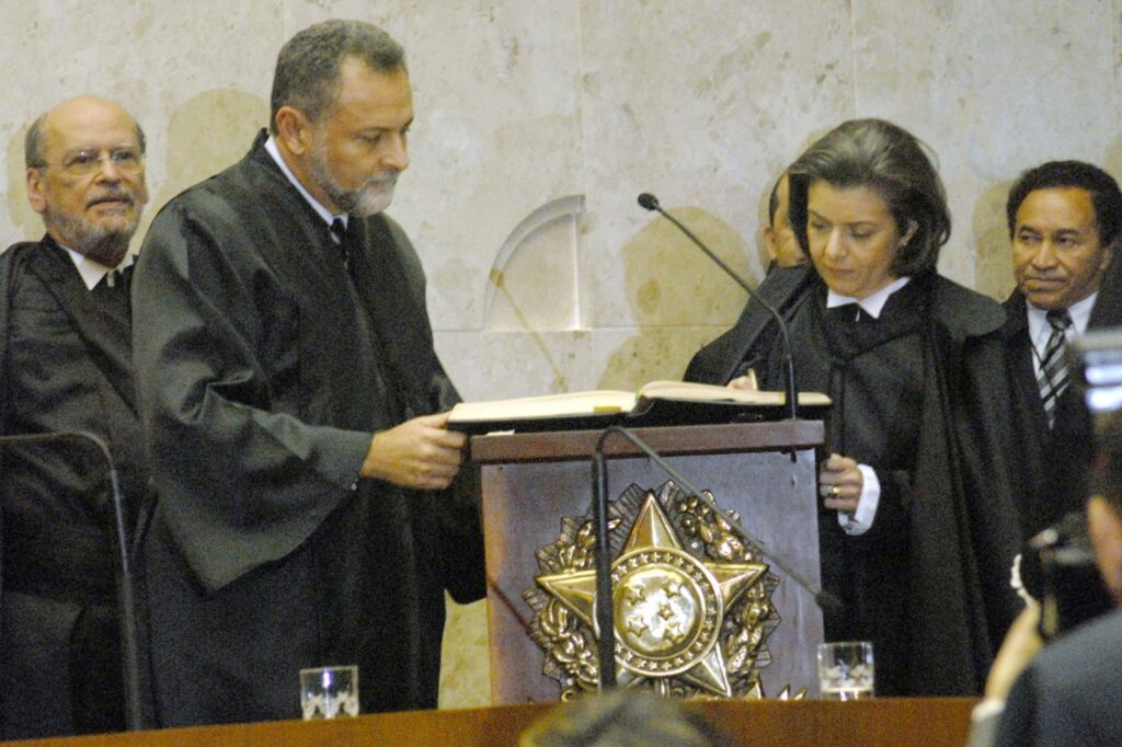 Fotografia da ministra Cármen Lúcia assinando o termo de posse como ministra do STF