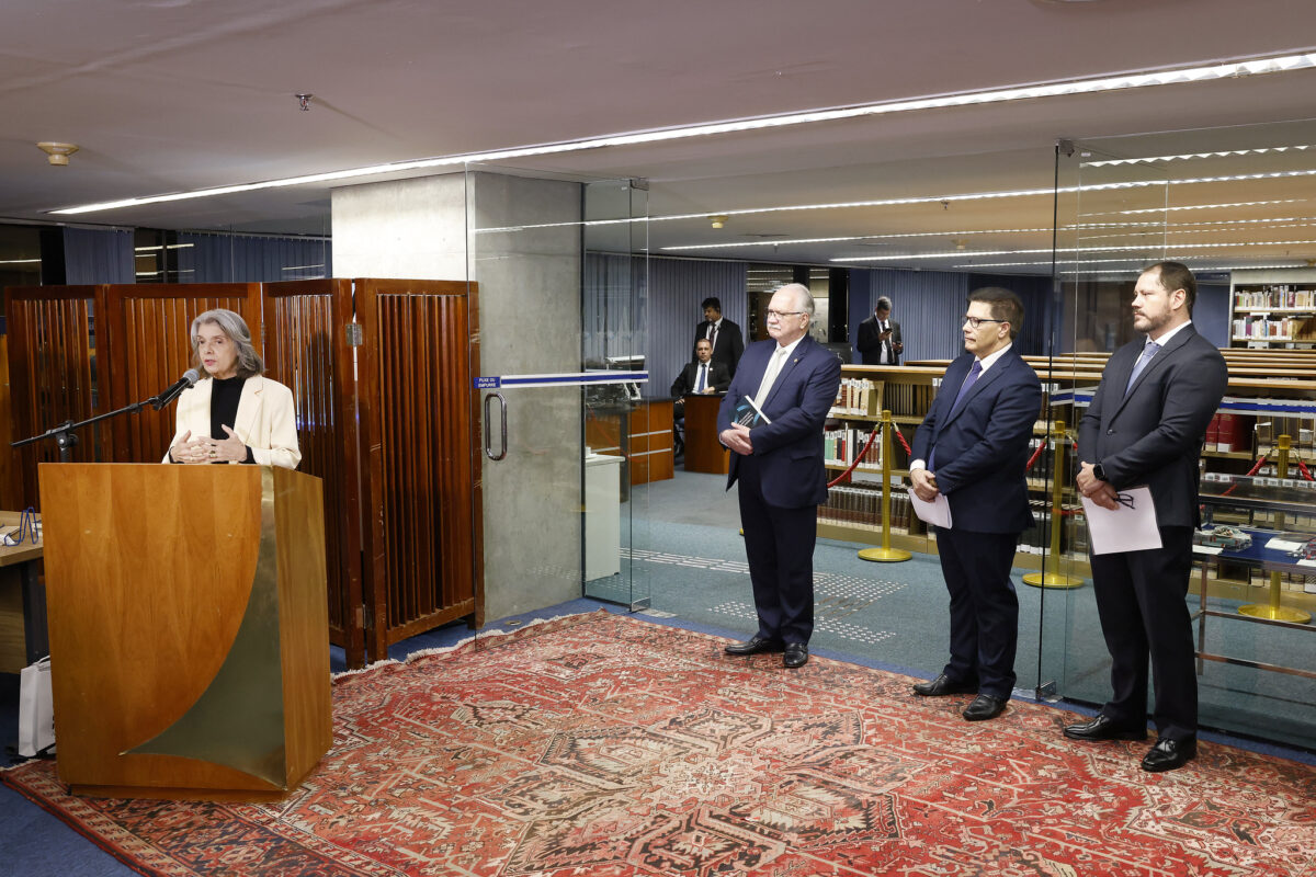 Fotografia do lançamento dos livros. Do lado esquerdo, a ministra Cármen Lúcia fala em um púlpito. Do lado direito, ao final, o ministro Edson Fachin e os dois autores das obras.